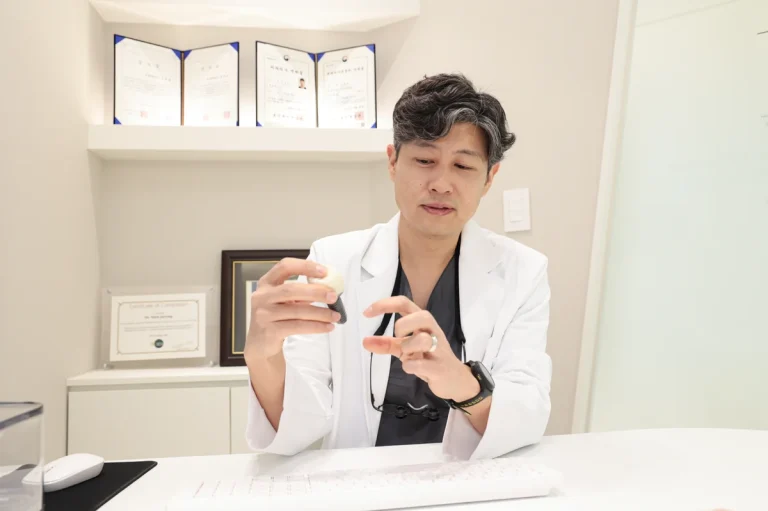 치주과 전문의 심재용 원장이 진료실에서 치아 모형으로 설명하는 모습