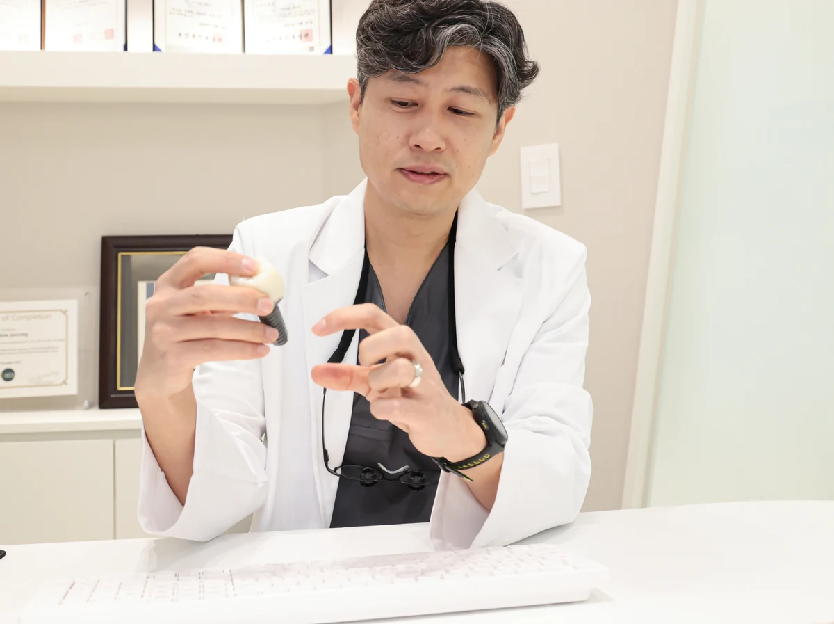 치주과 전문의 심재용 원장이 임플란트 모형을 들고 구조를 살펴보는 모습